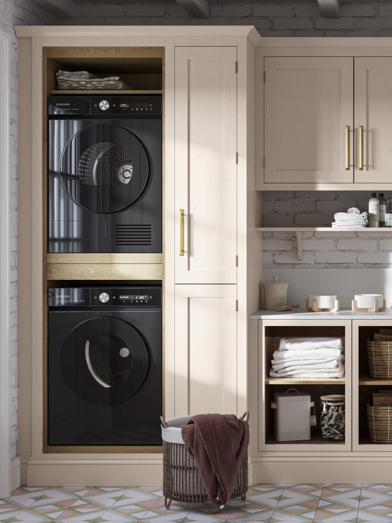 Utility room Wardley Shell cabinetry with washing machine and dryer built-in, a countertop and wall cabinets all matching, a laundry basket on the floor next to washing machine.