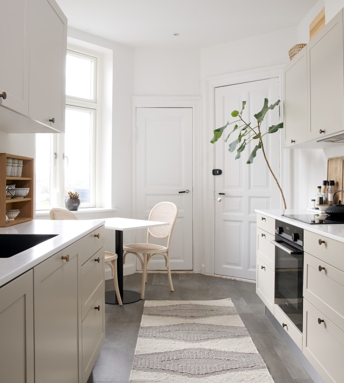 Beige retrokøkken Square Sand køkken fra INVITA med messing håndtag, hvid bordplade