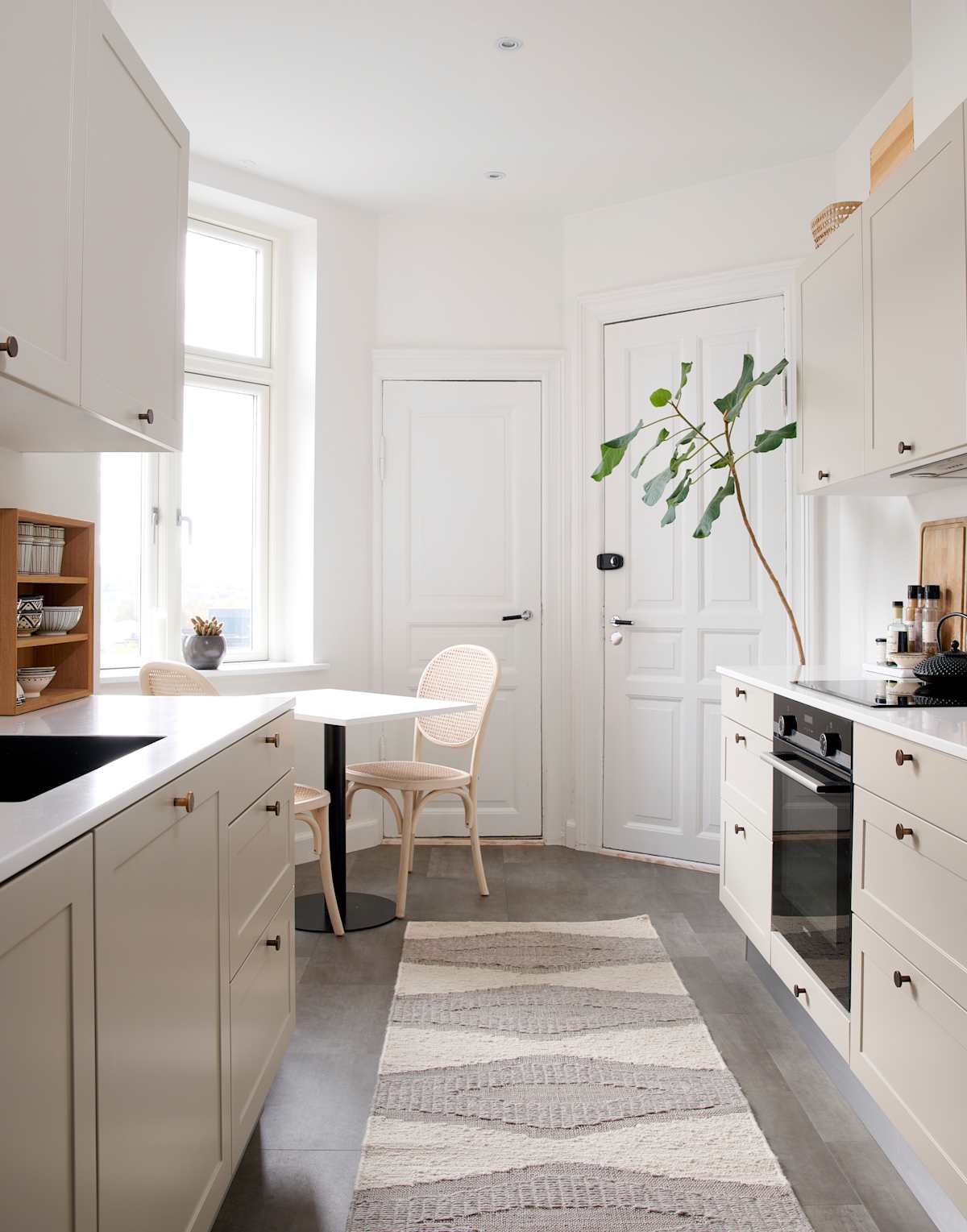 Beige retrokøkken Square Sand køkken fra INVITA med messing håndtag, hvid bordplade