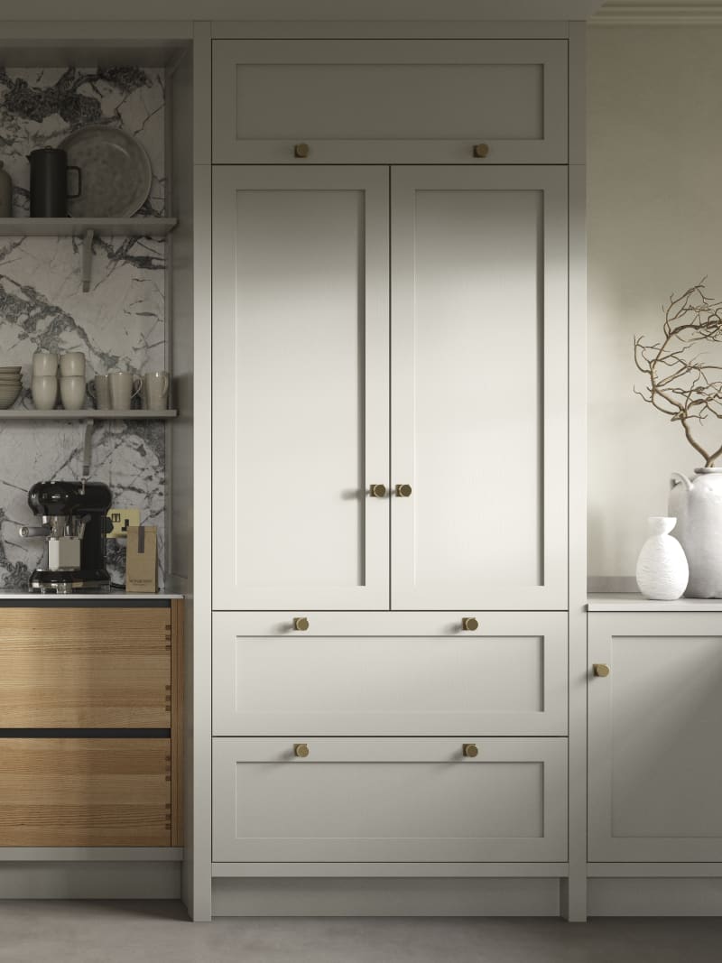 A neutral Shaker kitchen with Pebble and Nordic Craft cabinetry, marble splashback behind open shelves and paired with brass handles.