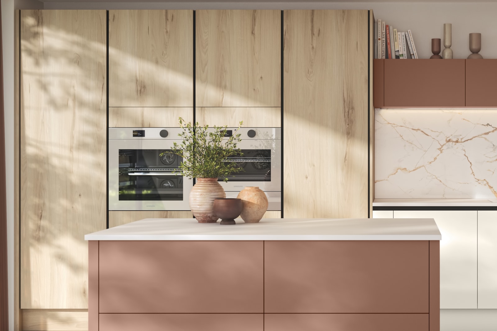 Integra Portobello Bosco as tall cabinets with integrated Samsung Ovens, white handleless Integra Soho cabinetry and a kitchen island in the shade Baked Clay, matching top cabinets and the beautiful fan above hob, all decorated with earth tone ceramics and plants.