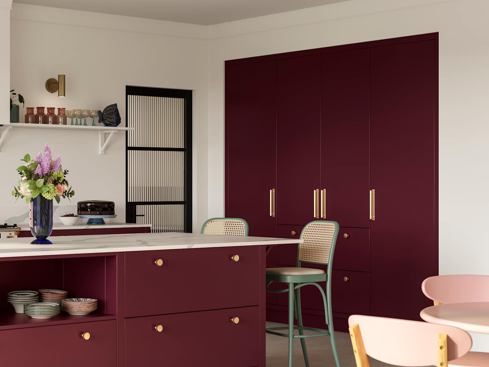 Modern slab front Soho Morello kitchen with built-in tall cabinets hiding integrated refrigerator, kitchen island with rattan bar stools at breakfast bar, Bianco calacatta worktop and upstand, brass knobs and open shelf in kitchen island holding eclectic eramics.