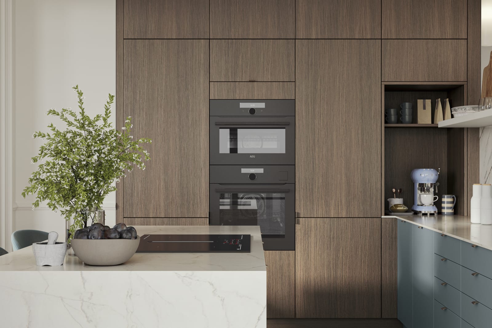 Soho Duck Blue kitchen from Magnet combined with ovens integrated into tall Nordic Nature cabinetry, white marble splashblack, paired beautifully with a bright brass tap and sink.