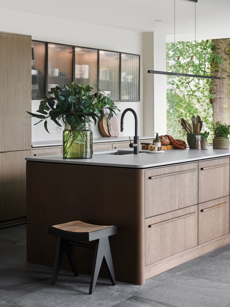 Magnet Kitchens 2021 Nordic Nature range with Fluted oak doors and Integra Hoxton Pebble cabinets with Dekton Aeri worktop. U-shaped kitchen with breakfast bar area.