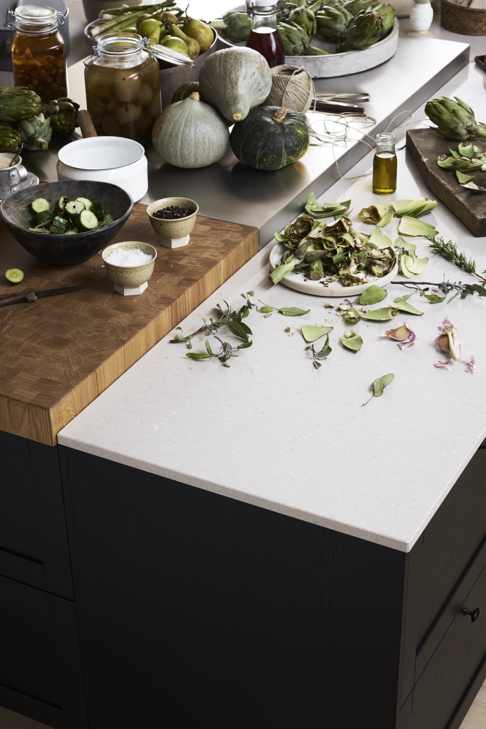 Ramsvik svarbets - Köksö från Marbodal med bänkskivor i tre olika material. Kvartkomposit med en centrerad del i rostfritt samt en nedsänkt huggkubbe.