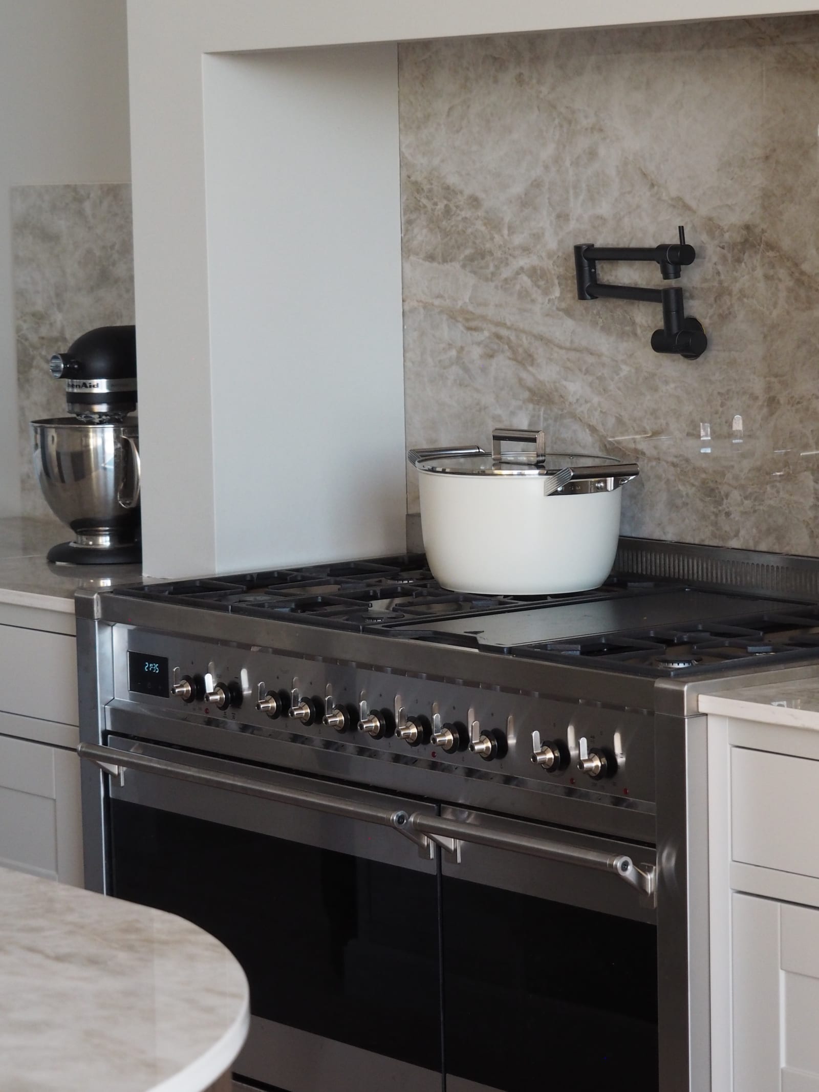 Komfur fra Smeg i rustfri stål med en hvid gryde på