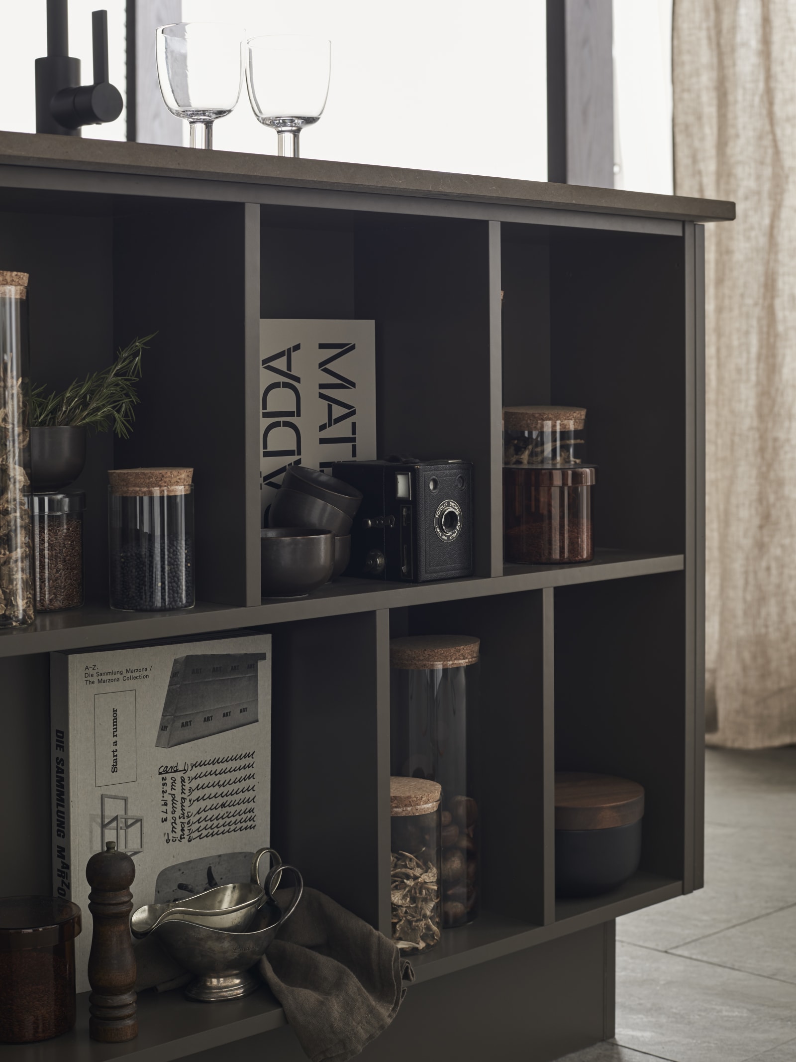 Åben hylde i køkkenøen i det brune køkken Athena Bark fra INVITA