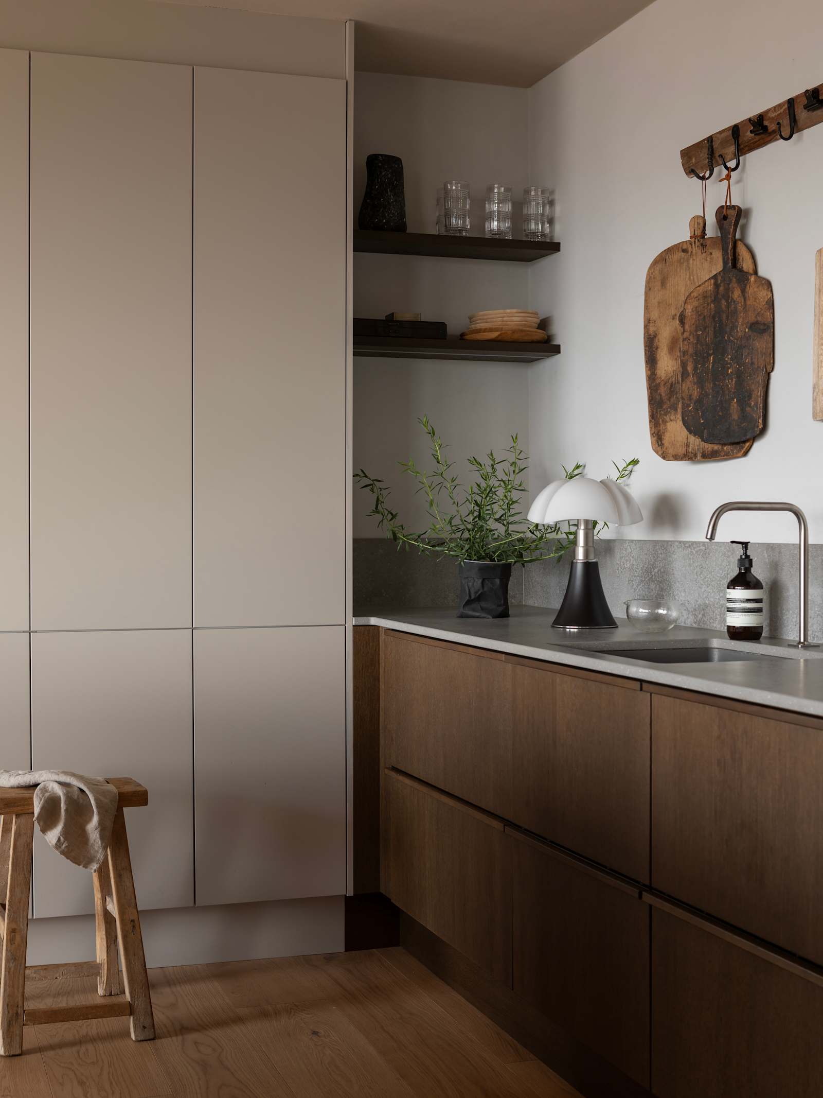 Køkken i brun egetræsfiner køkkenet Contours med matchende tre håndtag fra INVITA og beige højskabe Athena Sand