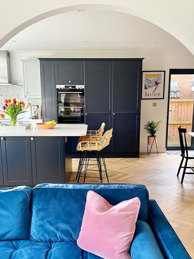 View of The Crombie family's Dunham Midnight and Dove grey contemporary and traditional kitchen with a bright blue sofa in the foreground.