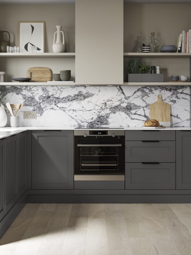 A dark grey Shaker kitchen with Charcoals cabinetry, paired with marble splashback and stylish black handles.