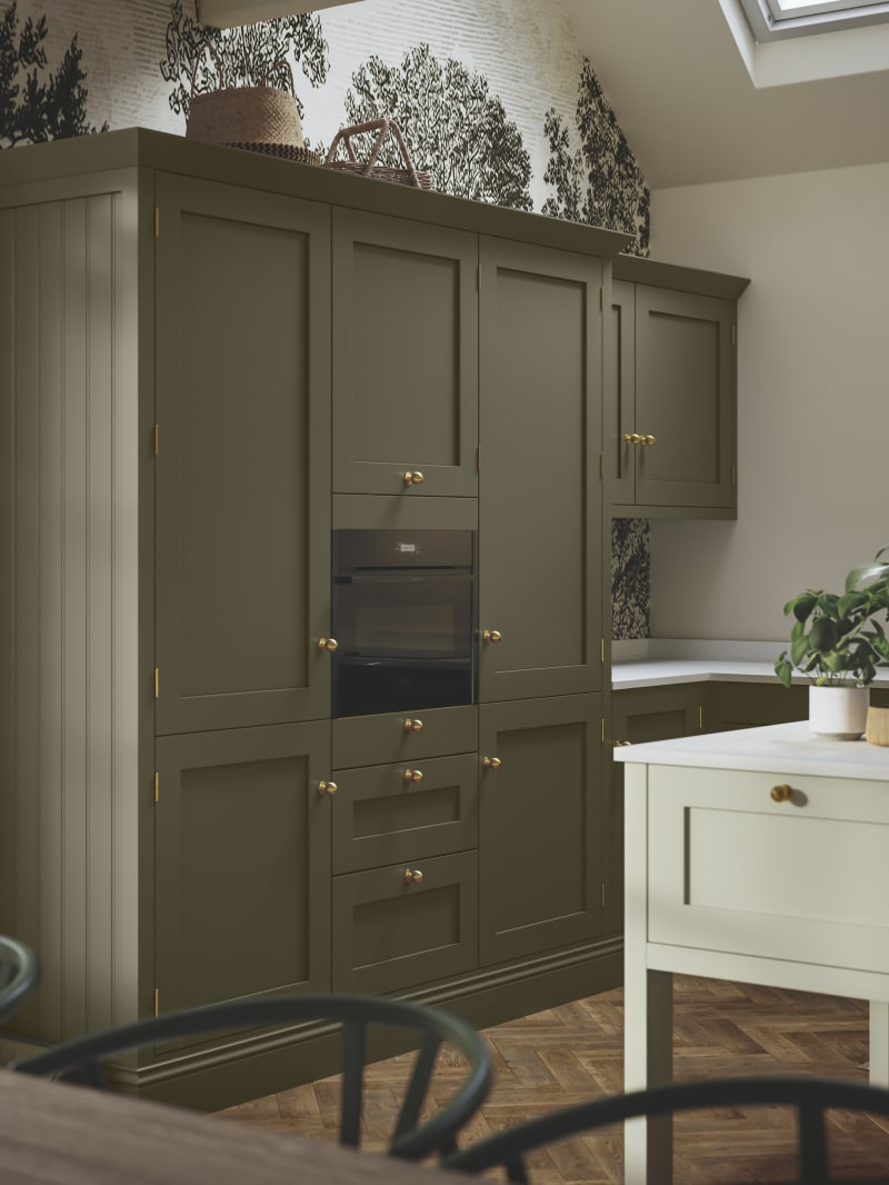 Tall Wardley Arboretum kitchen cabinets and a lighter kitchen island, all with brass details.