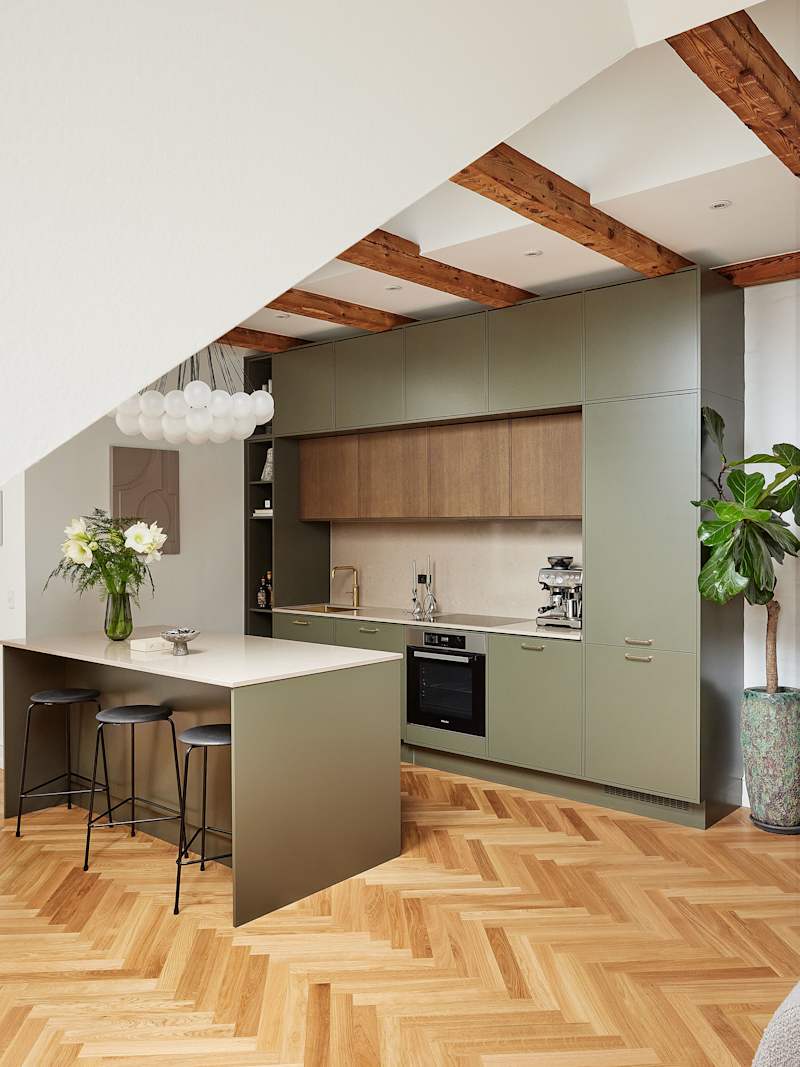 Grønt køkken med træskabe og køkkenø