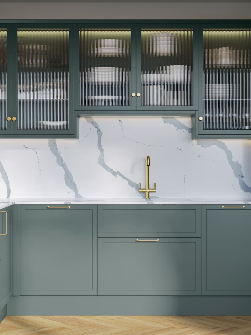 Modern Shaker kitchen Brunswick Spruce, a muted green shade, wall cabinets with fluted glass doors, Quartz Bianco Calacatta worktop and splashback, brass accessories like knobs, handles and tap, and a light wood herringbone floor.