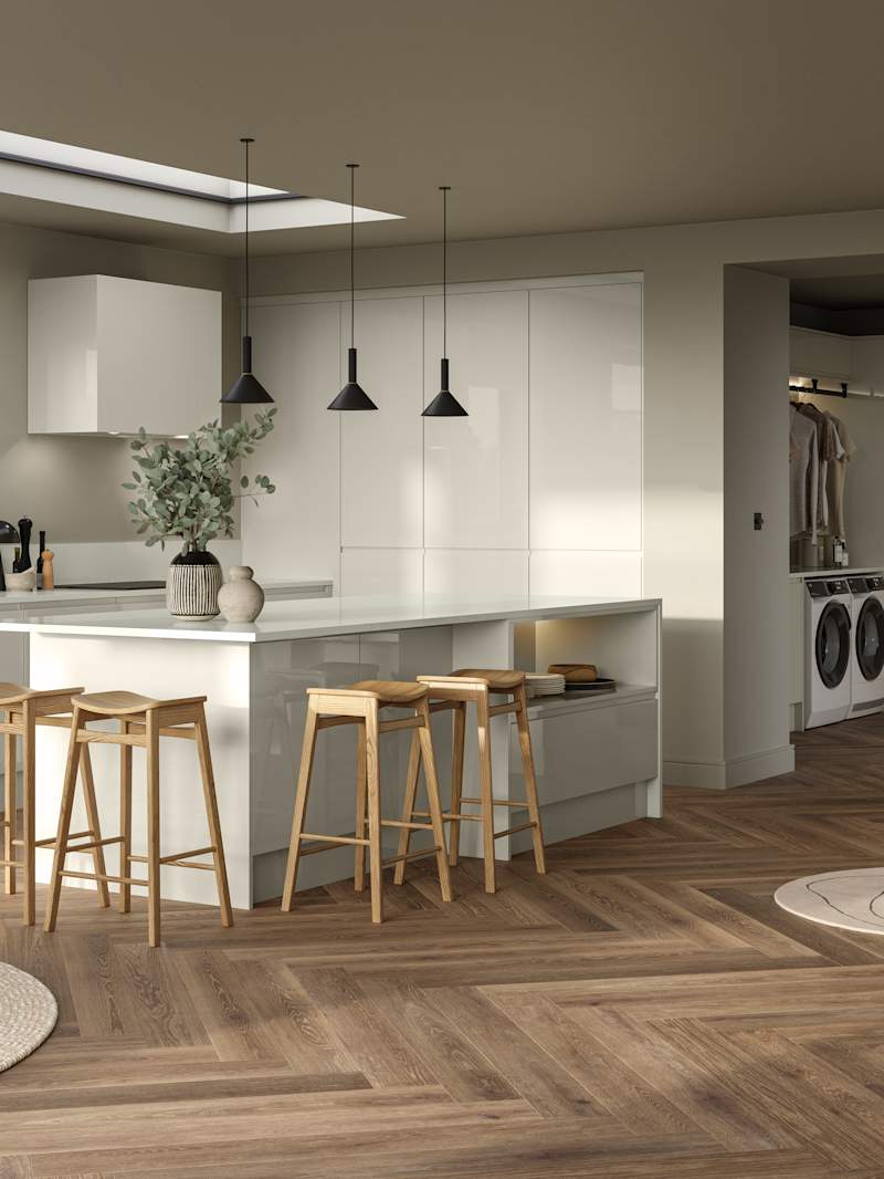Full room view of open plan contemporary Luna Gloss kitchen with a kitchen island, breakfast bar with wood stools, tall cabinetry, matching open shelves in living room with natural material decorations and Amtico smouldering oak parquet flooring.