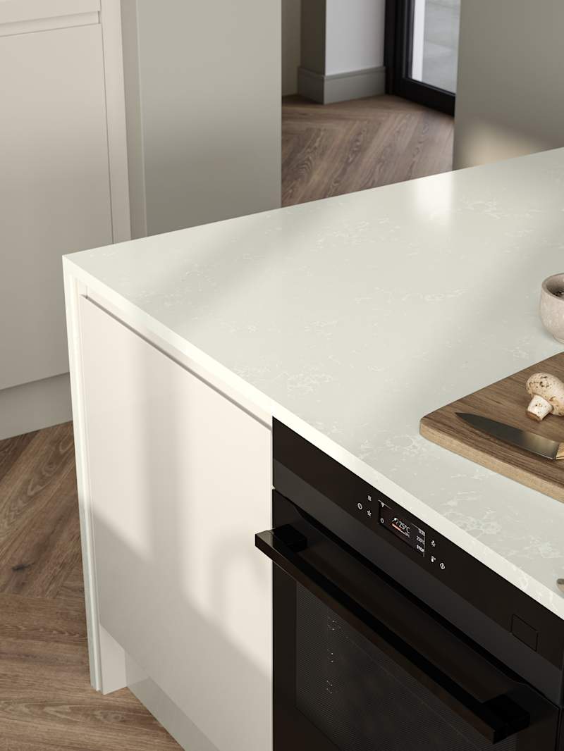 View of wood cutting board and knife with mushrooms on Minerva chalk venato worktop covered contemporary Luna Gloss Limestone kitchen island with integrated oven, Amtico smouldering oak parquet flooring.