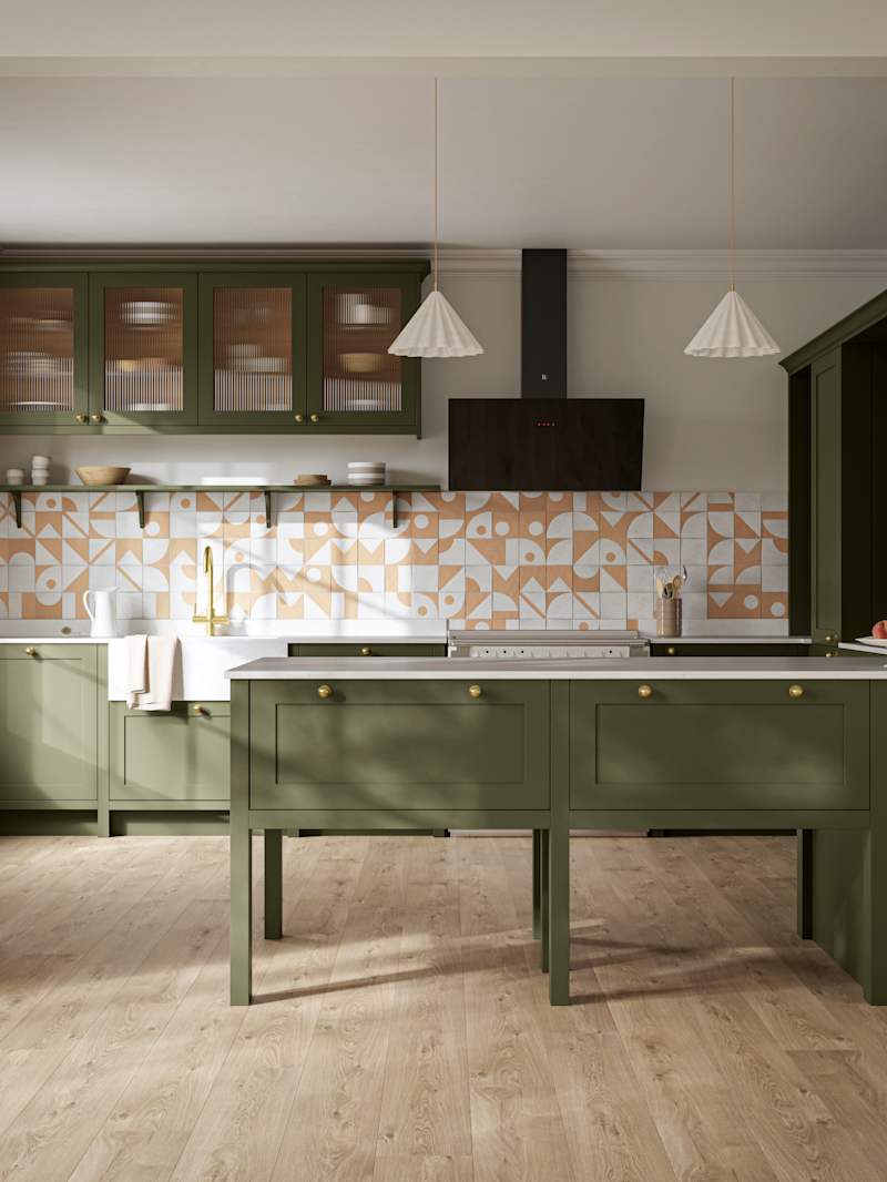 Premium Shaker kitchen Wardley Tailored green with traditional detailing, brass accessories, fluted glass wall vitrine cabinets, standalone Wardley Chalk Blush pantry, Classic Flint Grey oiled oak engineered wood flooring.
