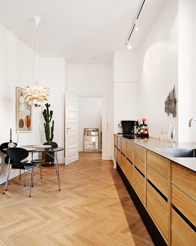 Kitchen in oak with black plinth and table top in curled steel