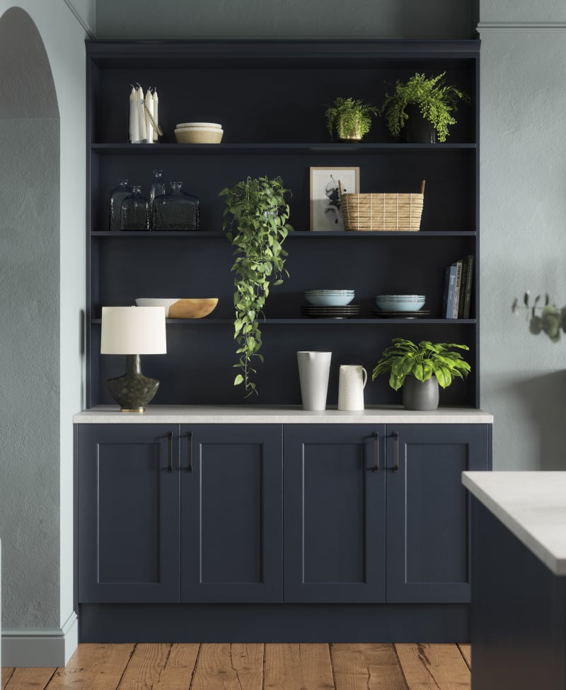 Modern country-style Ludlow Shaker kitchen in dark blue shade Midnight with matching blue open shelves and wall in open floorplan kitchen.