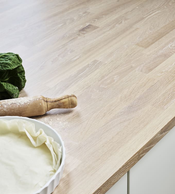 Mild og godlynt kjøkkenmodell i lys eik med liggende trestruktur og innfreste grep.