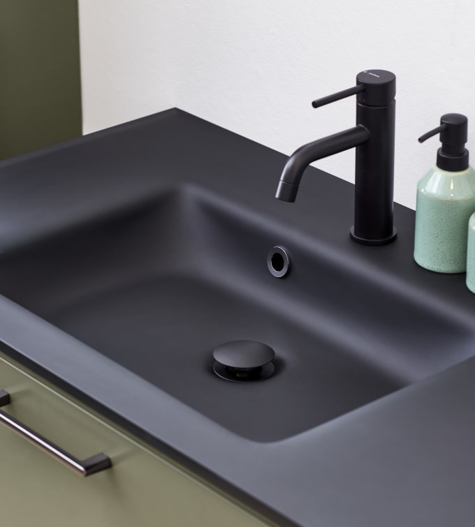 Nærbillede af sort armatur og sort vask i badeværelse Athena Pistacie fra INVITA