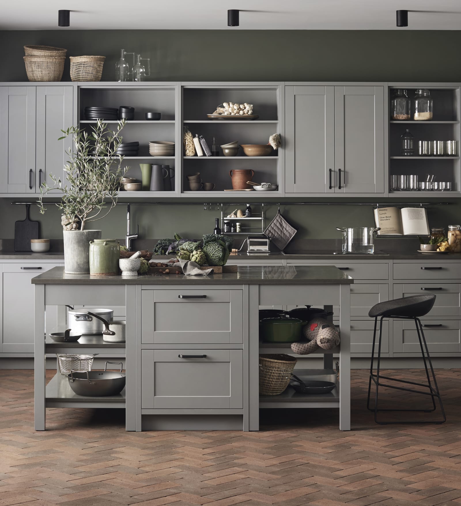 Marbodal Form Åska - kök i mellangrå kulör i PLUS-utförande som skapar en platsbyggd känsla. Avslutningshylla för köksön ger en lättare känsla samt skapar plats för förvaring. bänkskiva kvartskomposit Venato Scuro.