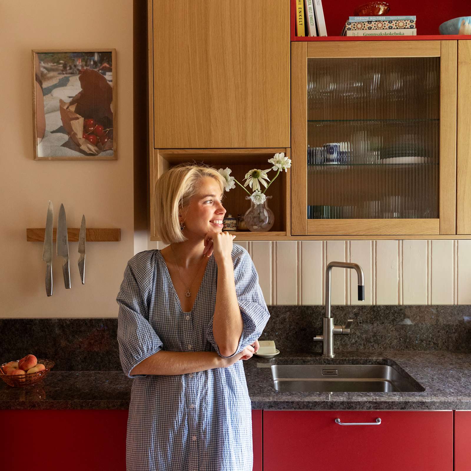 Thea Sofie Loch Næss  i Kirsebær-kjøkkenet sin fra Sigdal med Favn, eikefinér i beisfargen Natur og norsk naturstein benkeplate.