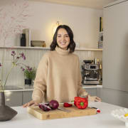 Yasmin Wyatt standing by the kitchen island, smiling to the camera.