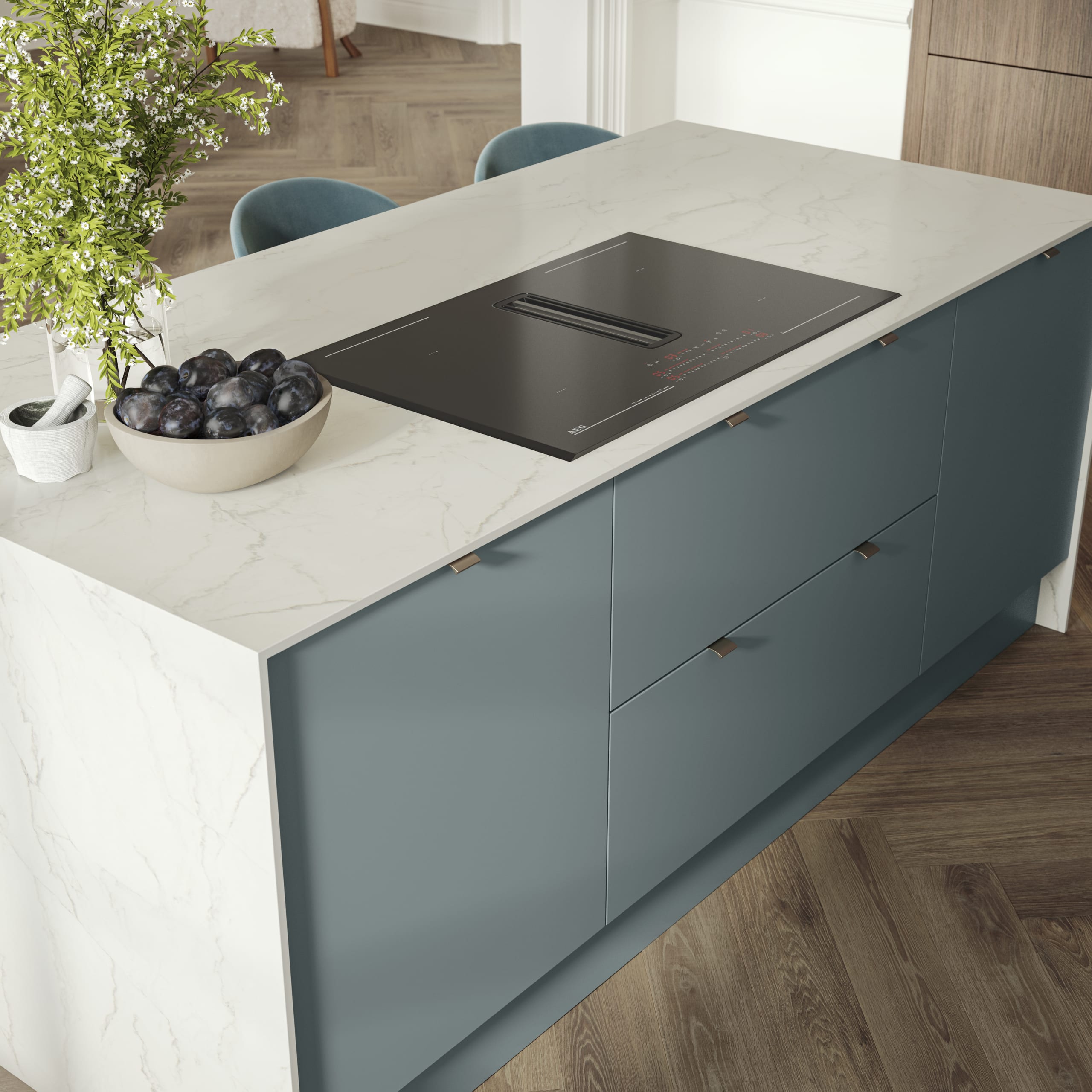 Overhead view of kitchen island with marbled dekton worktop, integrated hob and Soho Duck Blue cabinetry from Magnet.