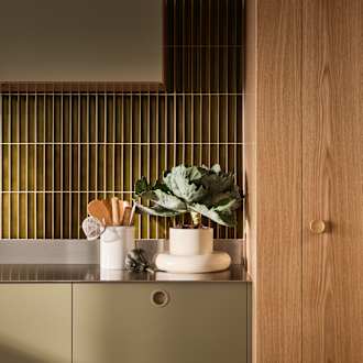 Jubilæumskøkken fra INVITA med træfinér eg, matchende vægpanel og grønne skaber inspireret av 1970'erne med infræsede greb