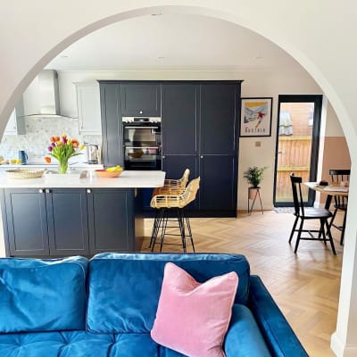 View of The Crombie family's Dunham Midnight and Dove grey contemporary and traditional kitchen with a bright blue sofa in the foreground.