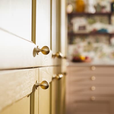 Close-up view of Douglas handles in Brushed Satin brass on Ludlow Harvest cabinets