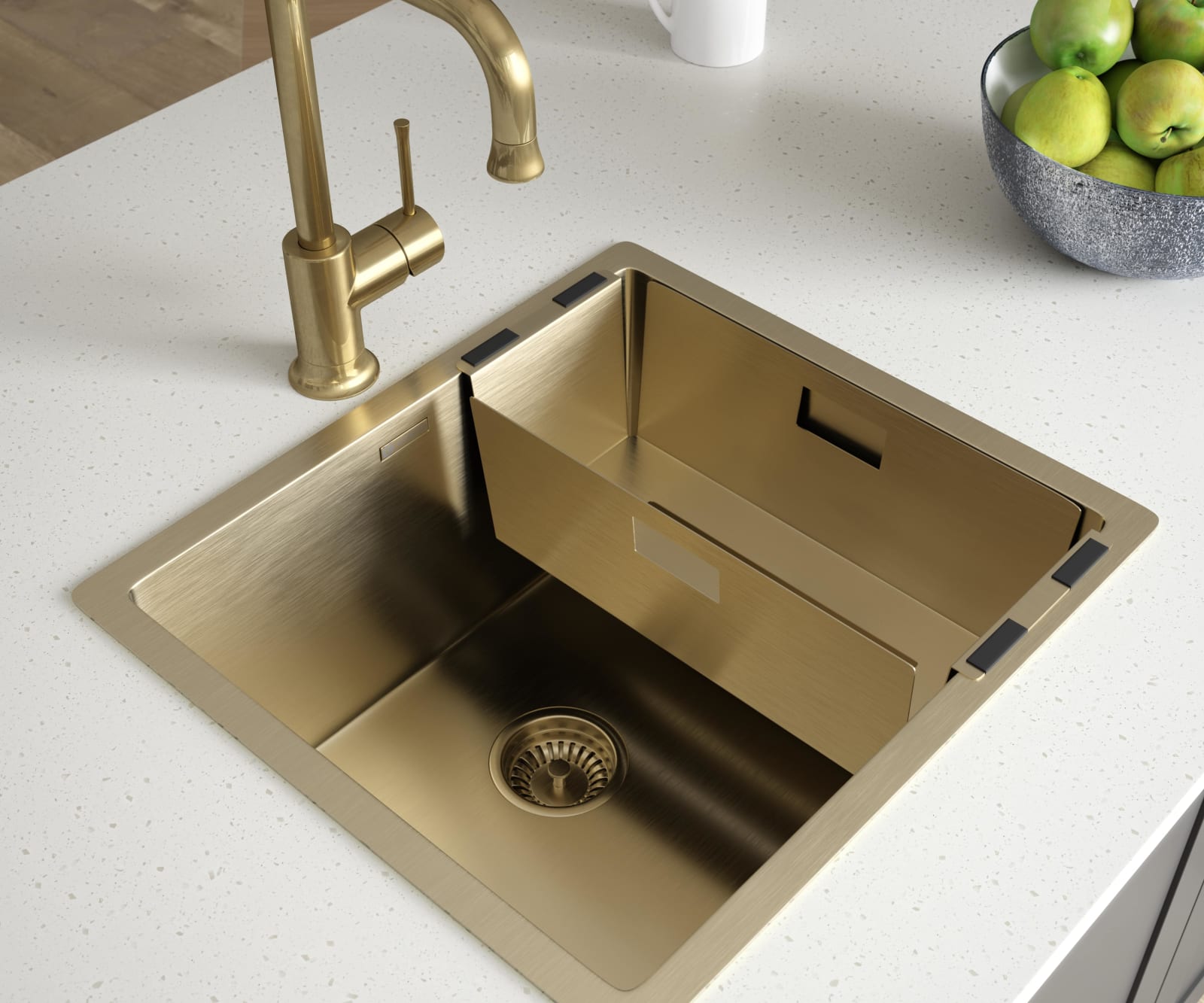 Overhead view of a brass sink and tap on a light worktop.