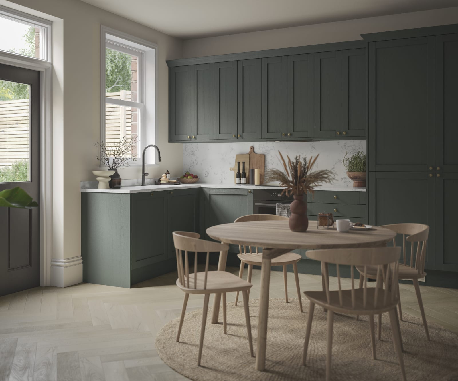 The Ambleside Shaker kitchen in a dark green, seen with a wooden dining table.