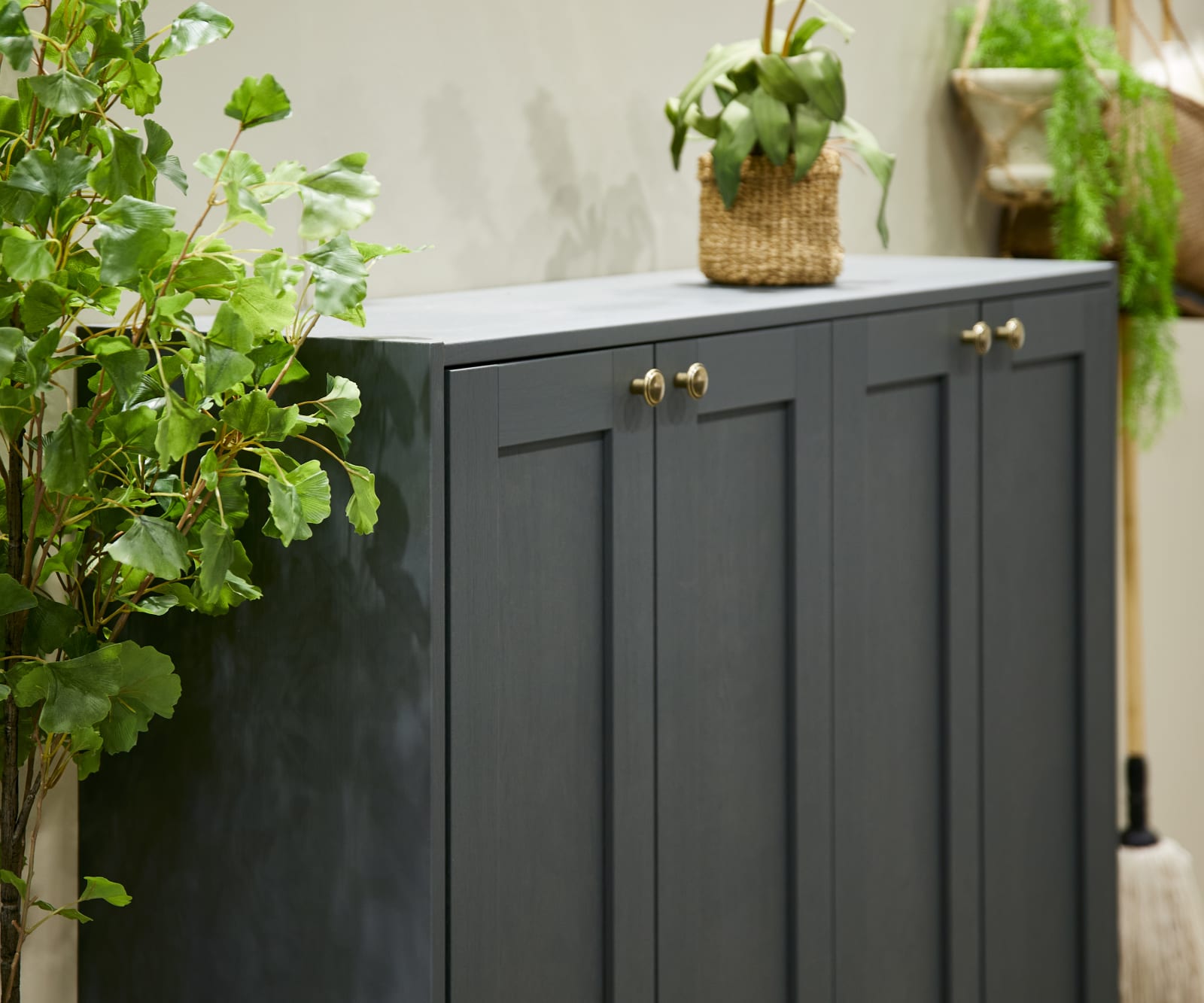 The Ambleside kitchen range in Fern, a dark shade of green, paired with brass handles.