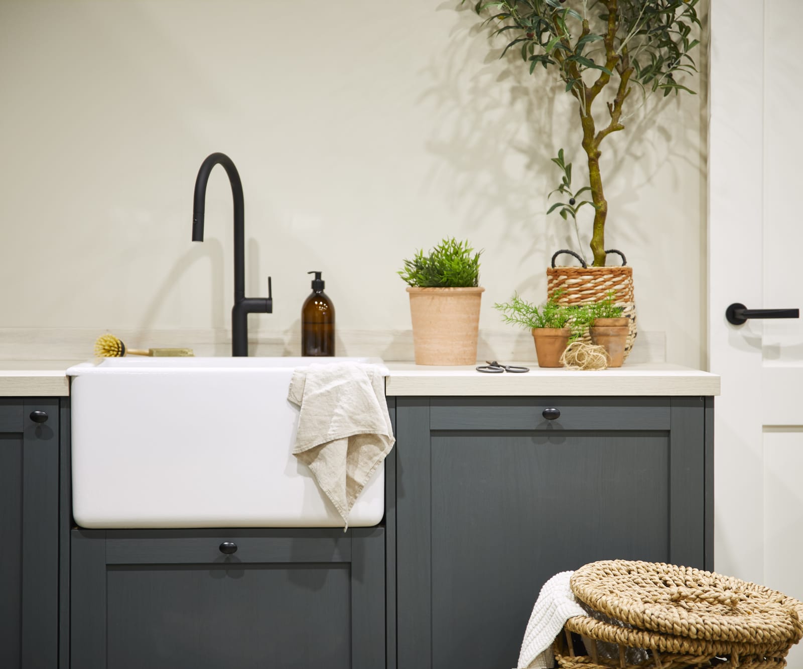 Magnet's Ambleside kitchen in Fern, a dark shade of green. Fitted with a butler's sink and matt black tap.