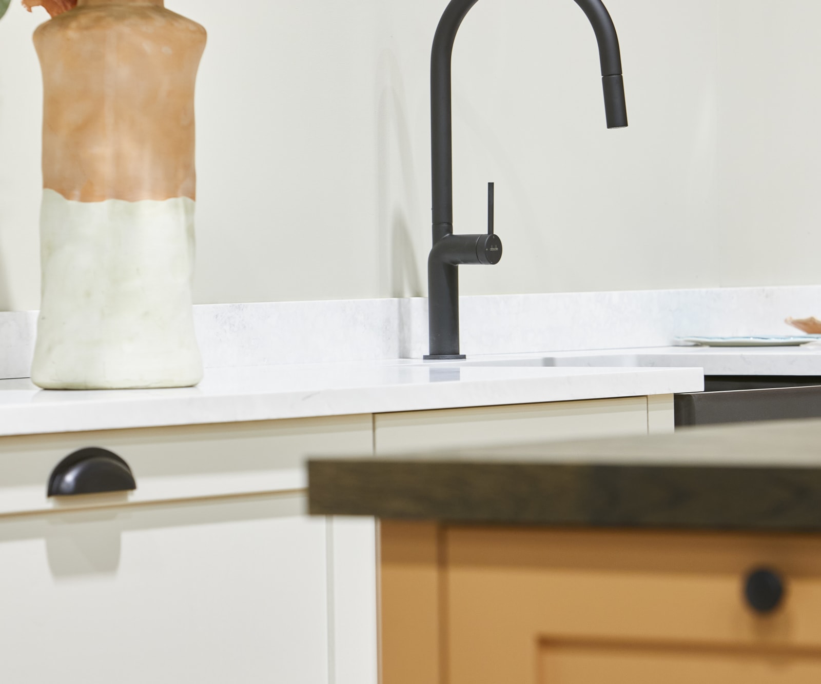 Close-up of black tap in white shaker kitchen Wardley with a corner of kitchen island in the foreground.