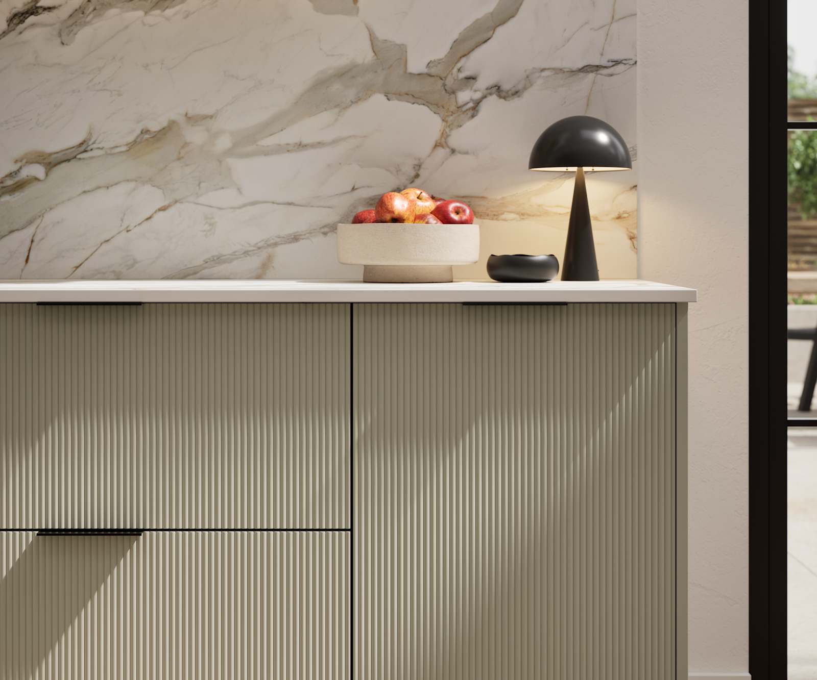 Fluted front kitchen Reed from Magnet in neutral shade French Clay, with a marbled splashback and black handles, herringbone wood flooring.