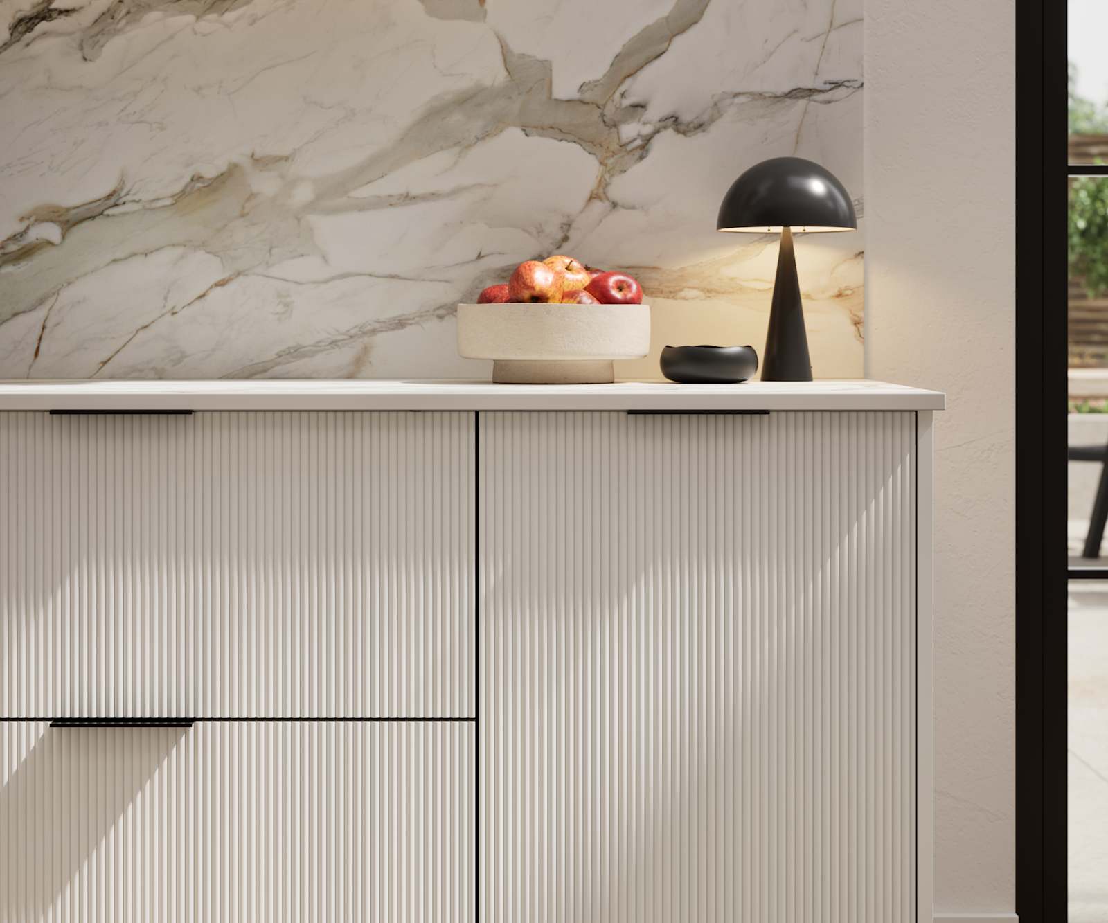 Fluted front kitchen Reed from Magnet in light shade Fresh Linen, with a marbled splashback and black handles, herringbone wood flooring.