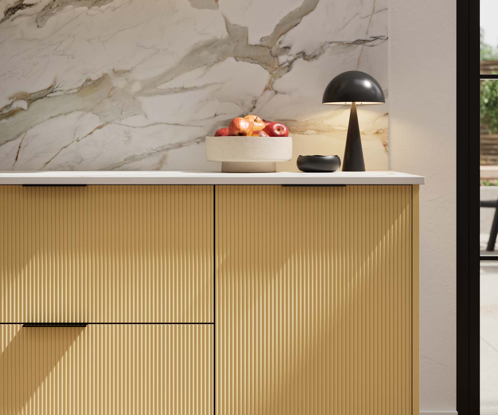 Fluted front kitchen Reed from Magnet in bright yellow shade Harvest, with a marbled splashback and black handles, herringbone wood flooring.