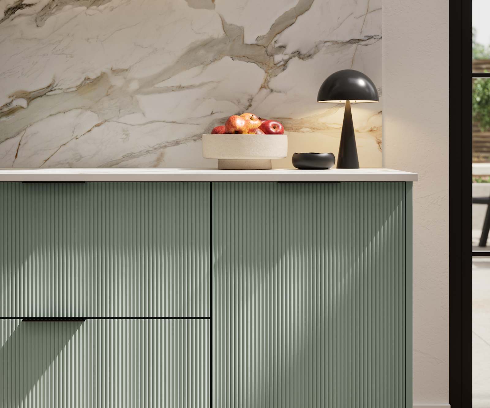 Fluted front kitchen Reed from Magnet in light green shade Eucalyptus Green, with a marbled splashback and black handles, herringbone wood flooring.