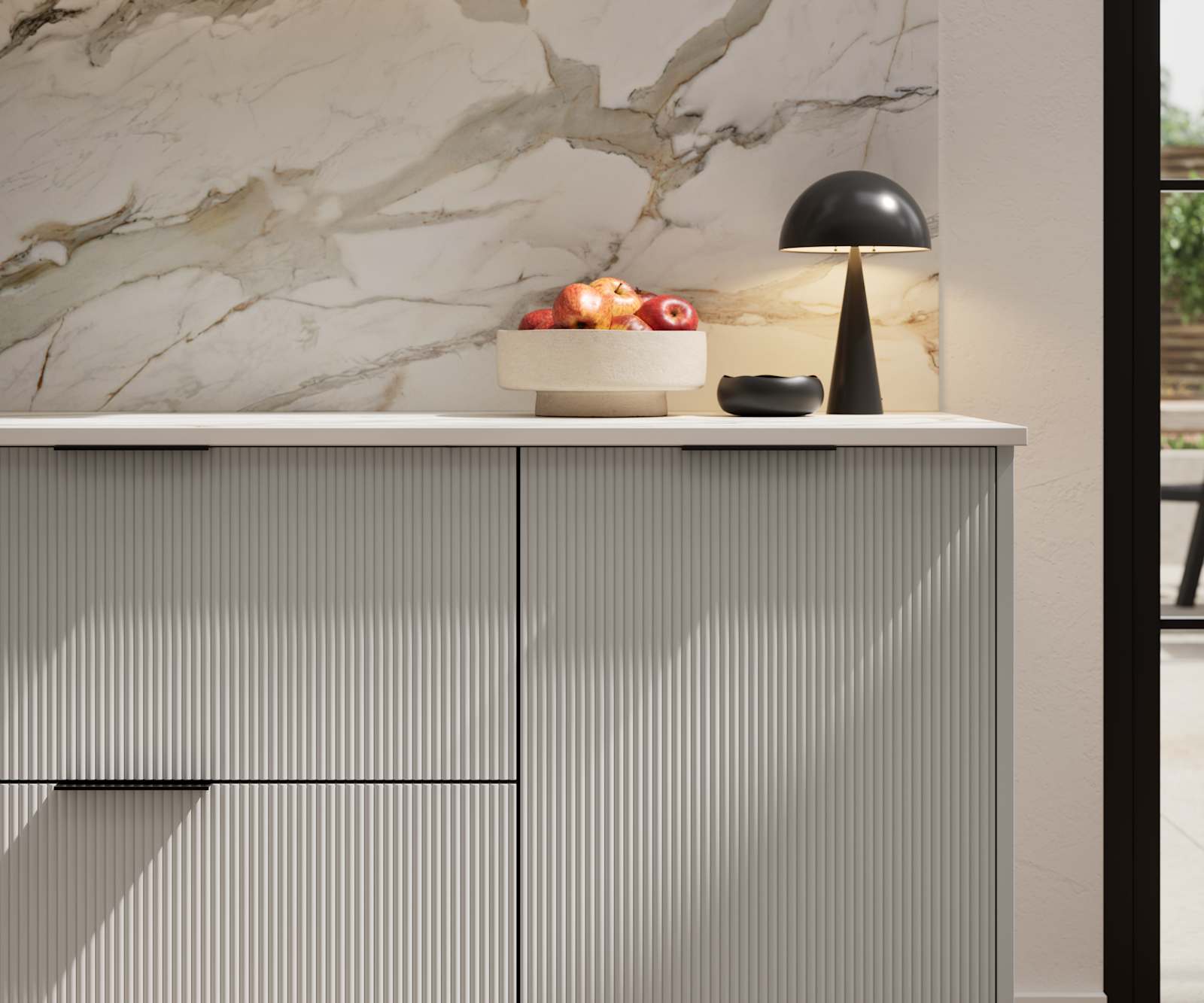 Fluted front kitchen Reed from Magnet in soft grey shade Dove Grey, with a marbled splashback and black handles, herringbone wood flooring.