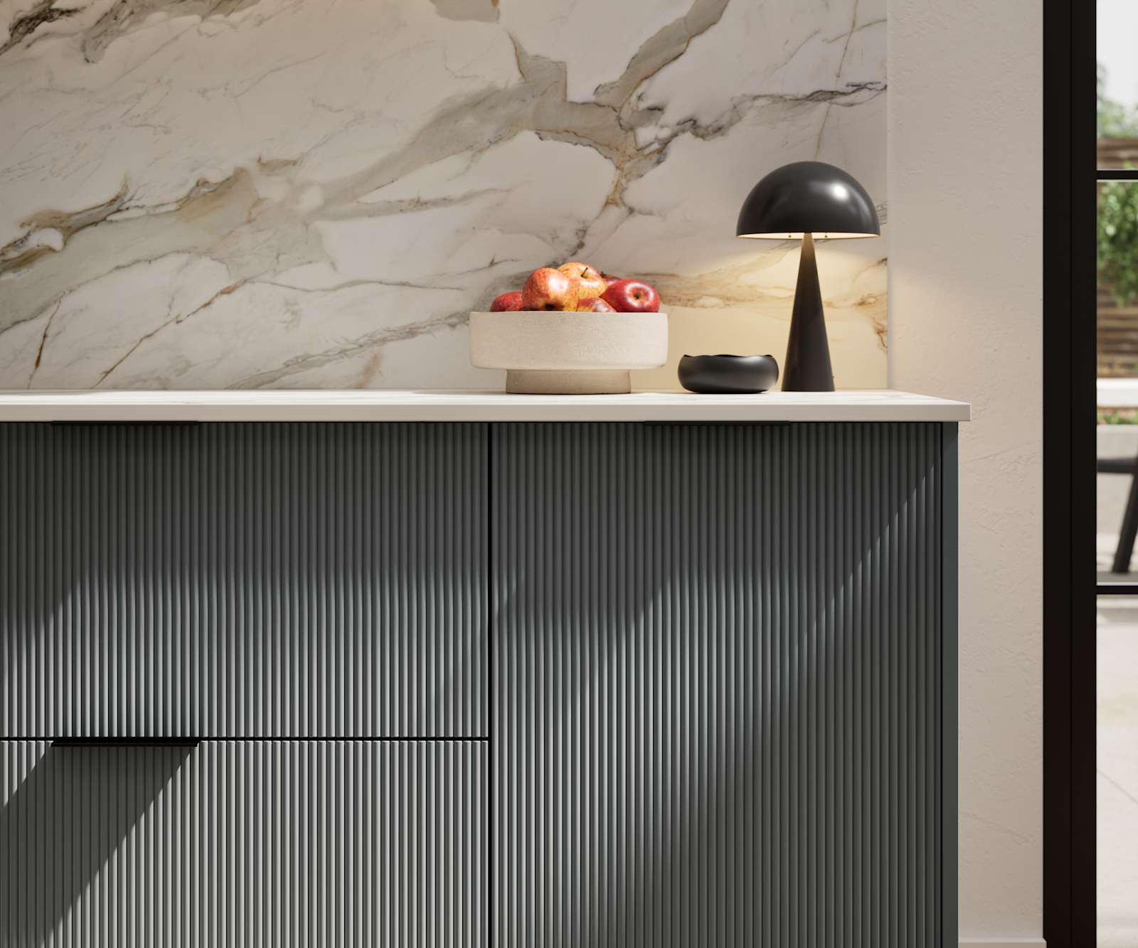 Fluted front kitchen Reed from Magnet in dark green shade Arboretum, with a marbled splashback and black handles, herringbone wood flooring.