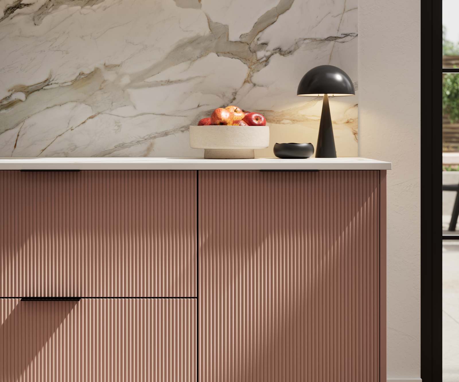 Fluted front kitchen Reed from Magnet in rich neutral green shade Baked Clay, with a marbled splashback and black handles, herringbone wood flooring.