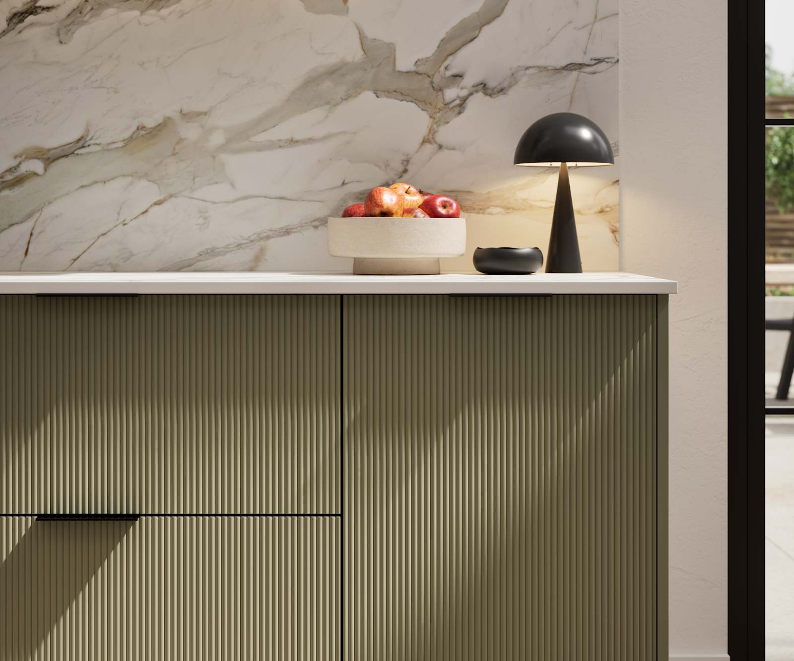 Fluted front kitchen Reed from Magnet in deep green shade Balmoral, with a marbled splashback and black handles, herringbone wood flooring.