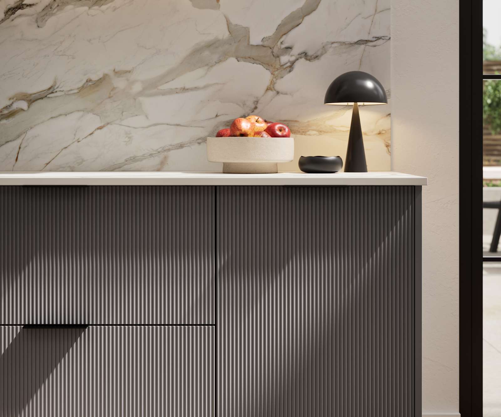 Fluted front kitchen Reed from Magnet in dark grey shade Charcoals, with a marbled splashback and black handles, herringbone wood flooring.