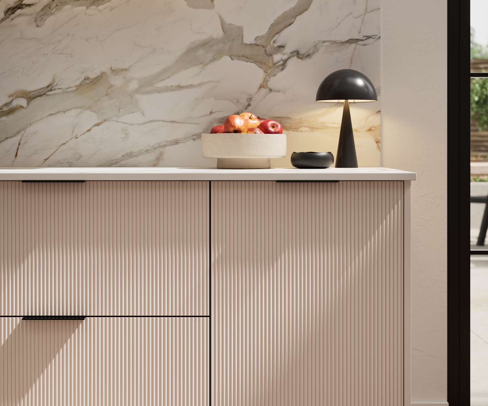 Fluted front kitchen Reed from Magnet in light neutral shade Shell, with a marbled splashback and black handles, herringbone wood flooring.