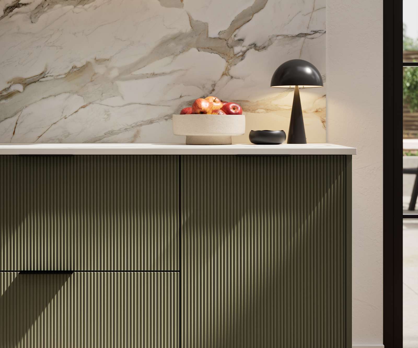 Fluted front kitchen Reed from Magnet in dark green shade Tailored Green, with a marbled splashback and black handles, herringbone wood flooring.