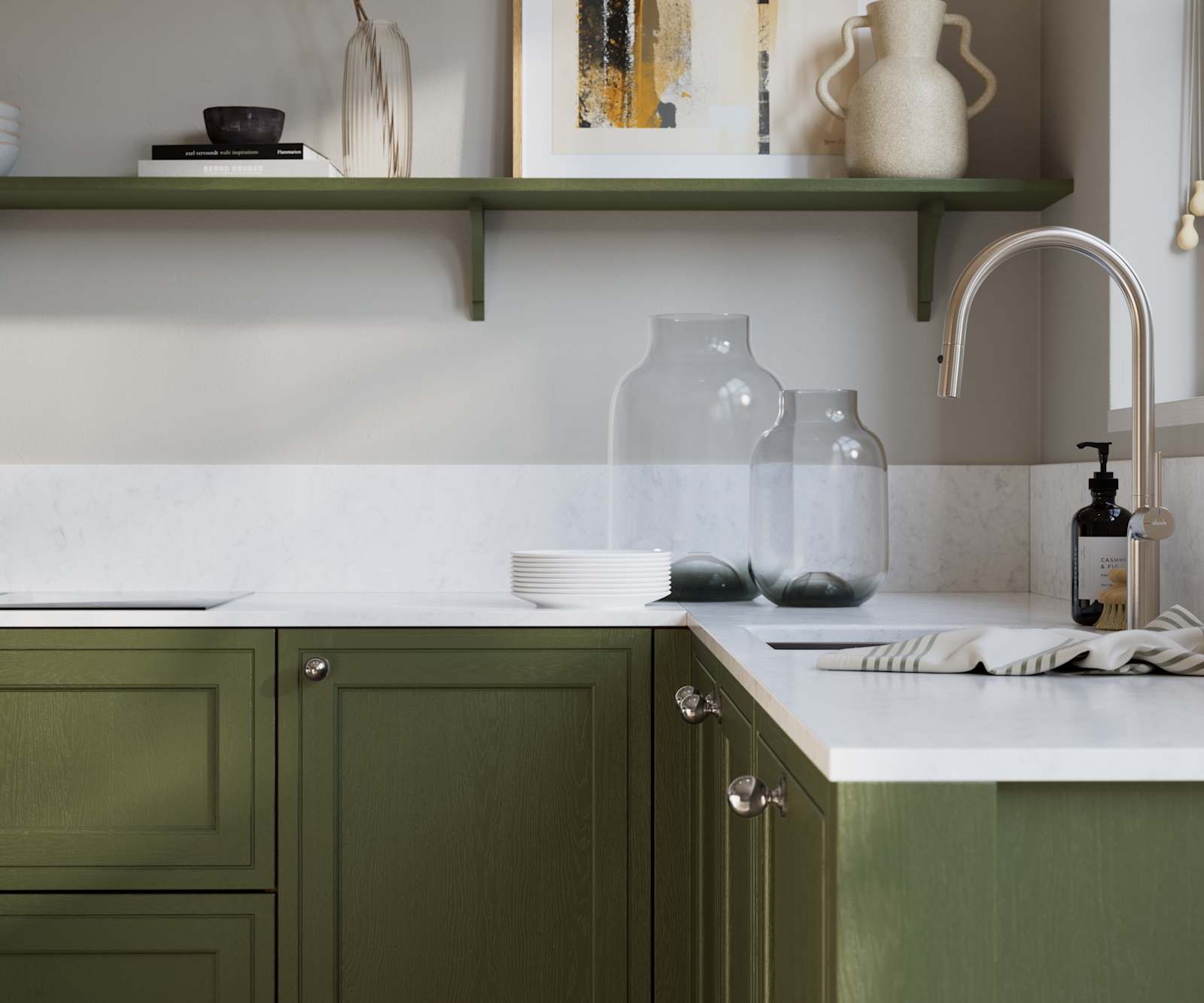 Bewdley Tailored Green painted wood grain Shaker kitchen cabinetry with steel knobs, steel tap, white marbled worktop and matching backsplash, an open shelf on the wall above cabinets with ceramics and a vase of flowers.