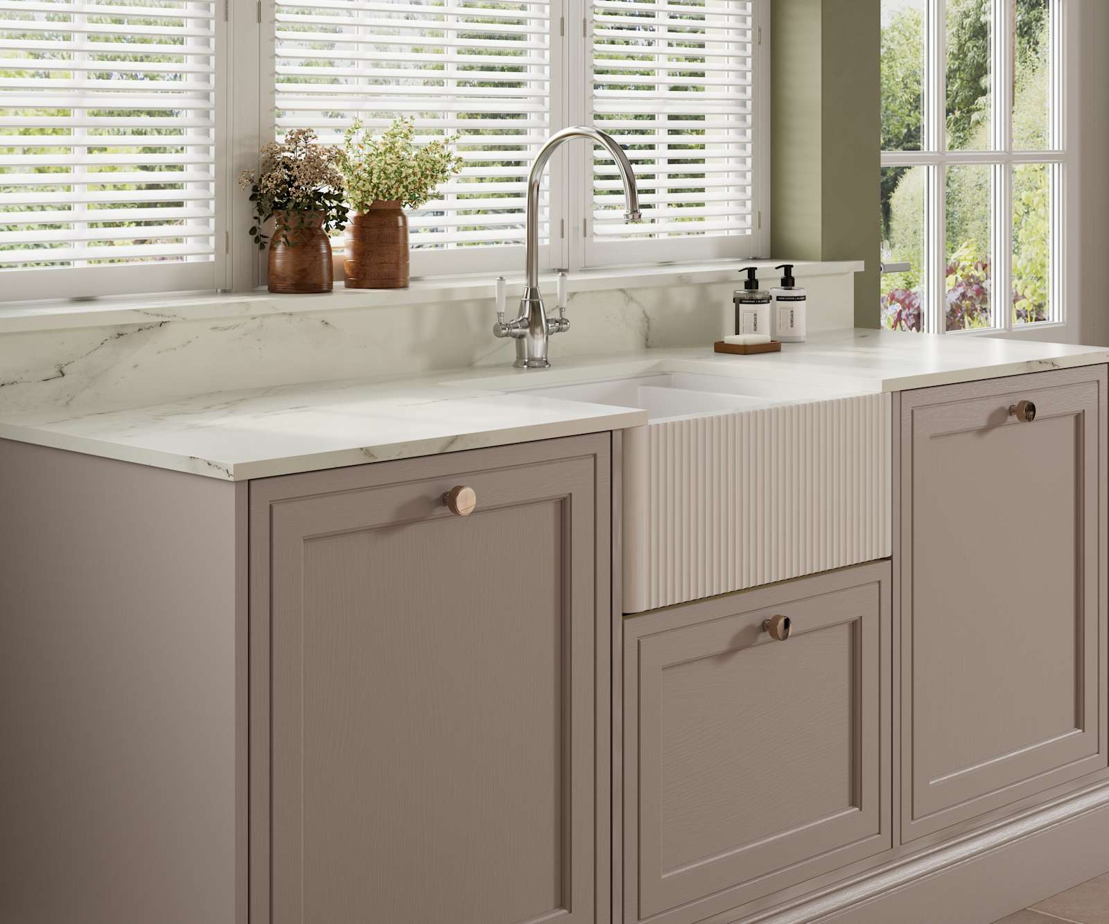 Shaker style painted wood grain cabinets Bewdley in the shade Cornish Clay with a marbled worktop and matching upstand, striped belfast sink with ceramic handle stainless steel tap.