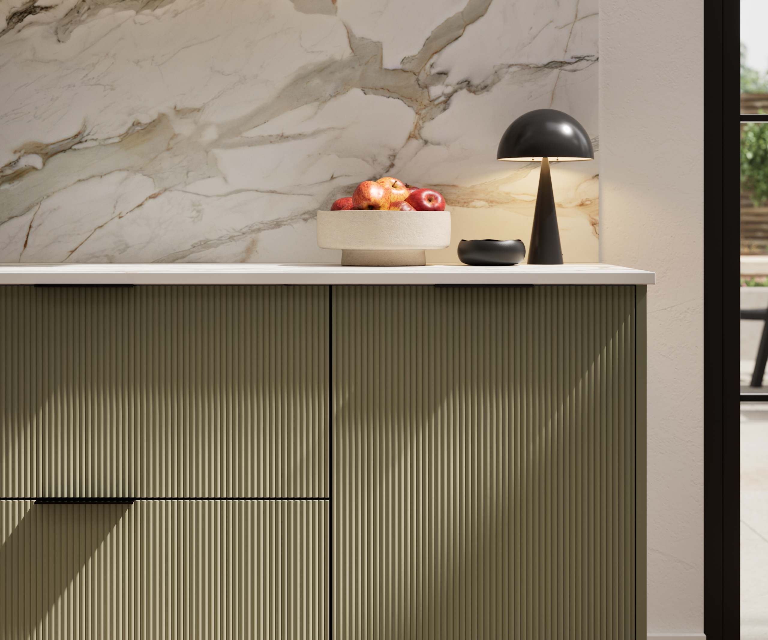 Fluted front kitchen Reed from Magnet in deep green shade Balmoral, with a marbled splashback and black handles, herringbone wood flooring.